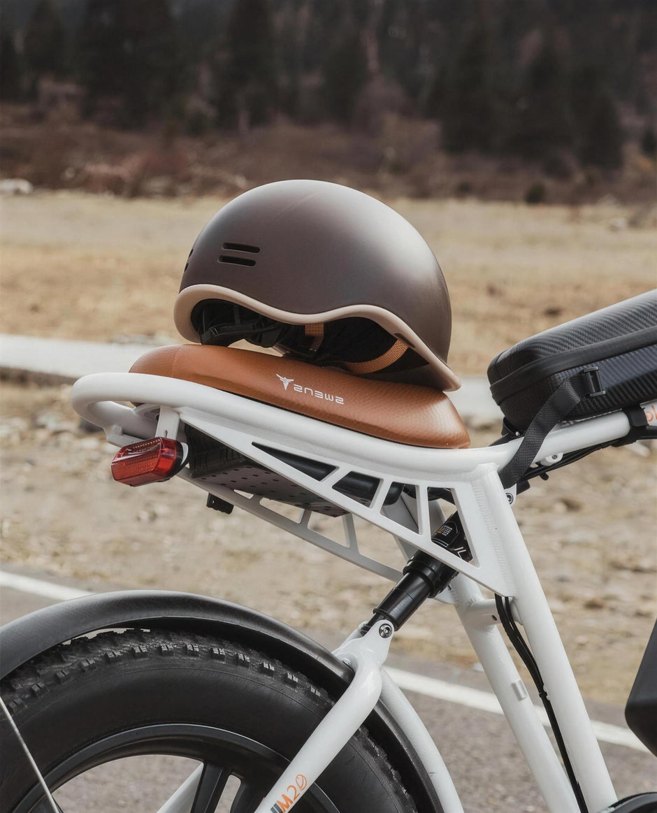 ENGWE Urban helmet in matte brown resting on an ENGWE M20 e-bike leather saddle outdoors