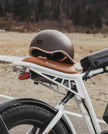 ENGWE Urban helmet in matte brown resting on an ENGWE M20 e-bike leather saddle outdoors