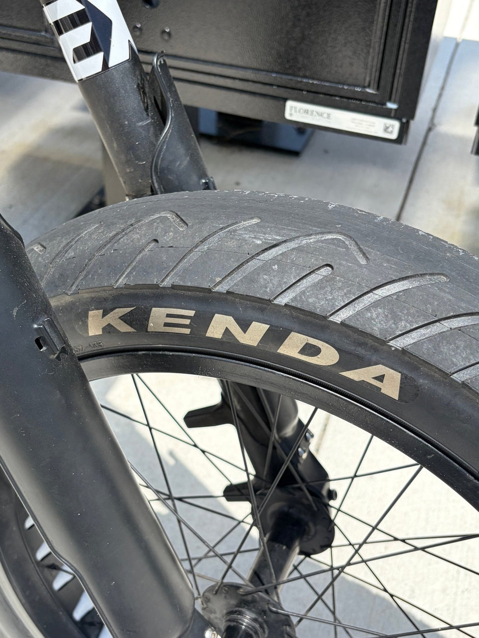 Kenda Kraze semi-slick tread close-up showing the smooth center strip and water-evacuating shoulder grooves