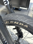 Kenda Kraze semi-slick tread close-up showing the smooth center strip and water-evacuating shoulder grooves