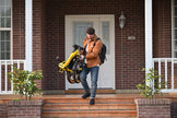 Rider carrying the folded Revi Rebel 2 electric bike, folded size 34.7 by 27.6 by 11.8 inches